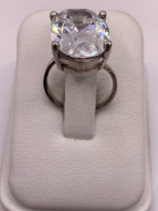 Anillo solitario ajustable con circonia blanca brillante en plata .925, vista frontal en estuche blanco