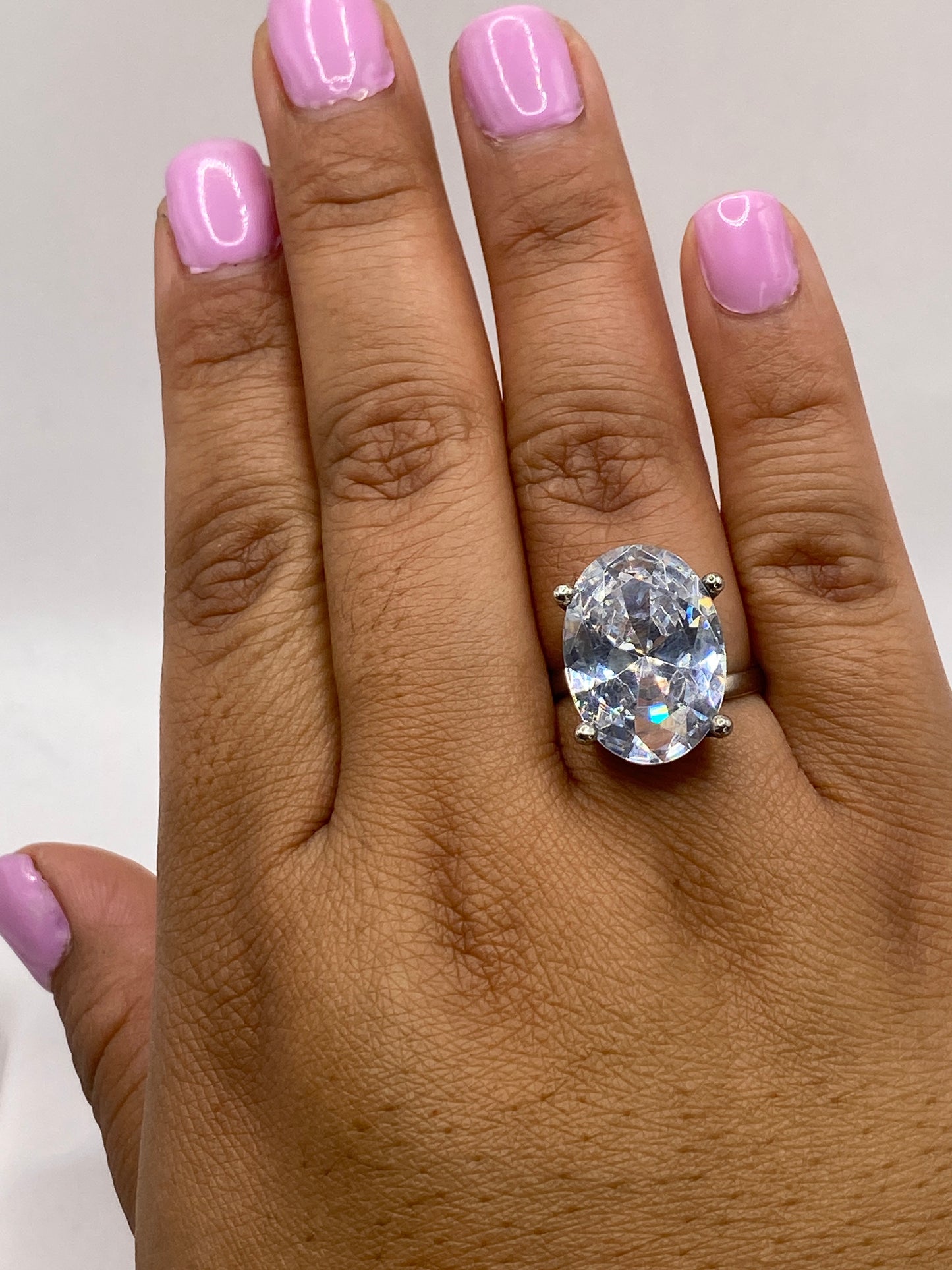 Anillo solitario en dedo de mujer con circonia blanca cristalina, luz natural