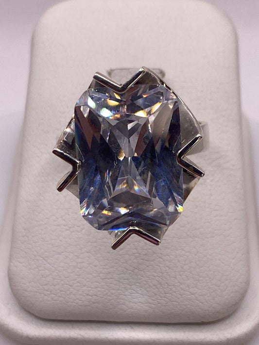 Anillo de plata solitario con circonia cristalina sobre estuche blanco, vista frontal