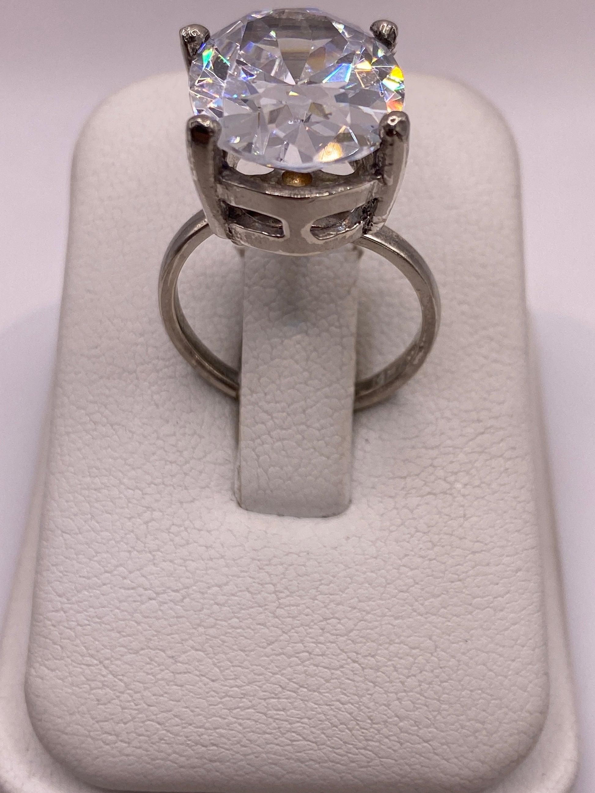 Anillo solitario de plata con circonia cristalina, vista frontal sobre dedo