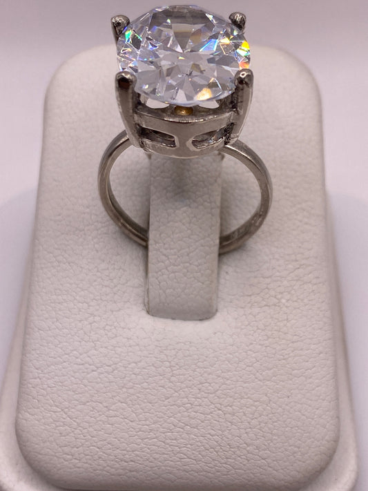 Anillo solitario de plata con circonia cristalina, vista frontal sobre dedo