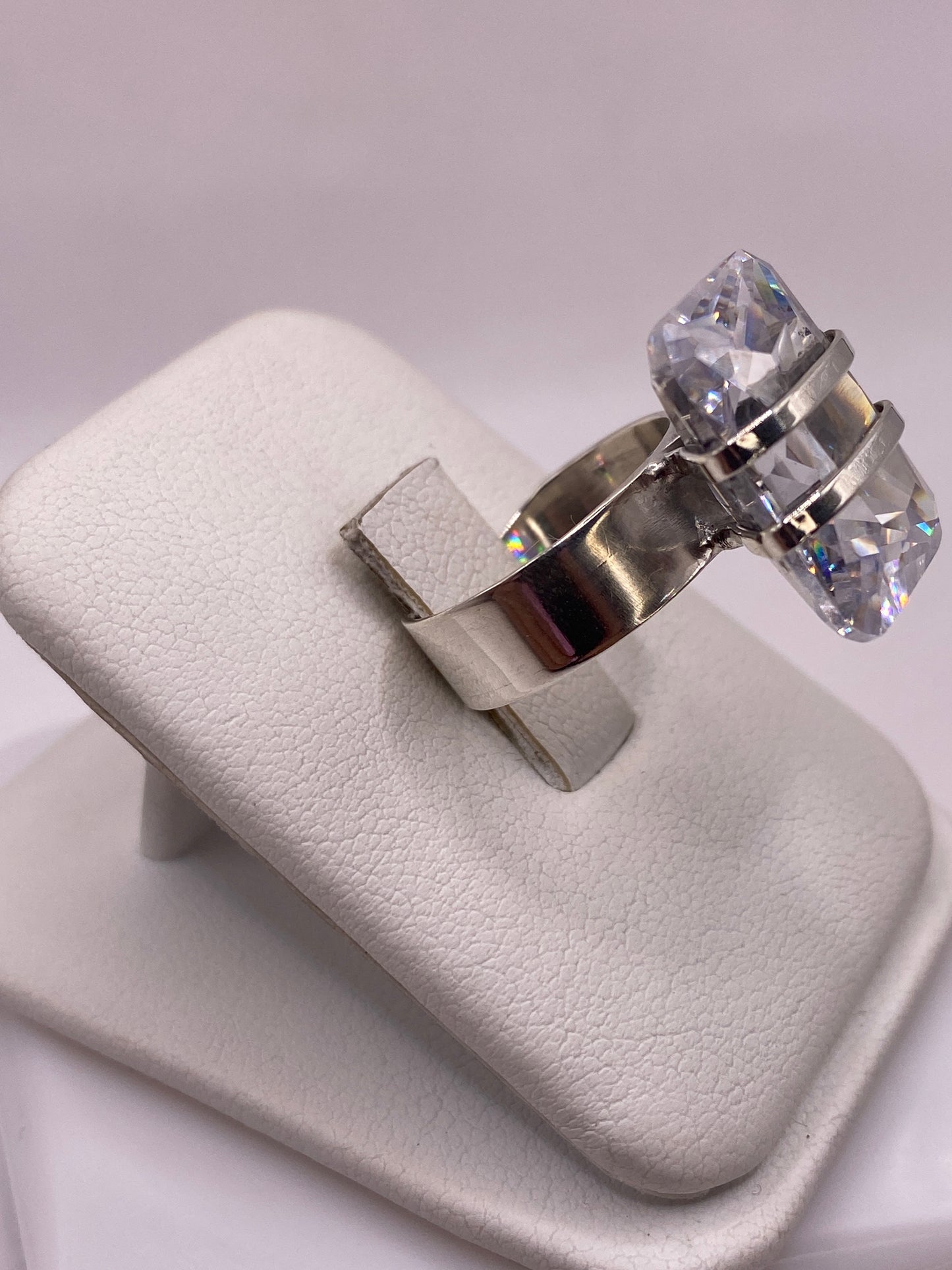 Anillo solitario en mano de mujer mostrando la banda ancha y el fuego de la piedra