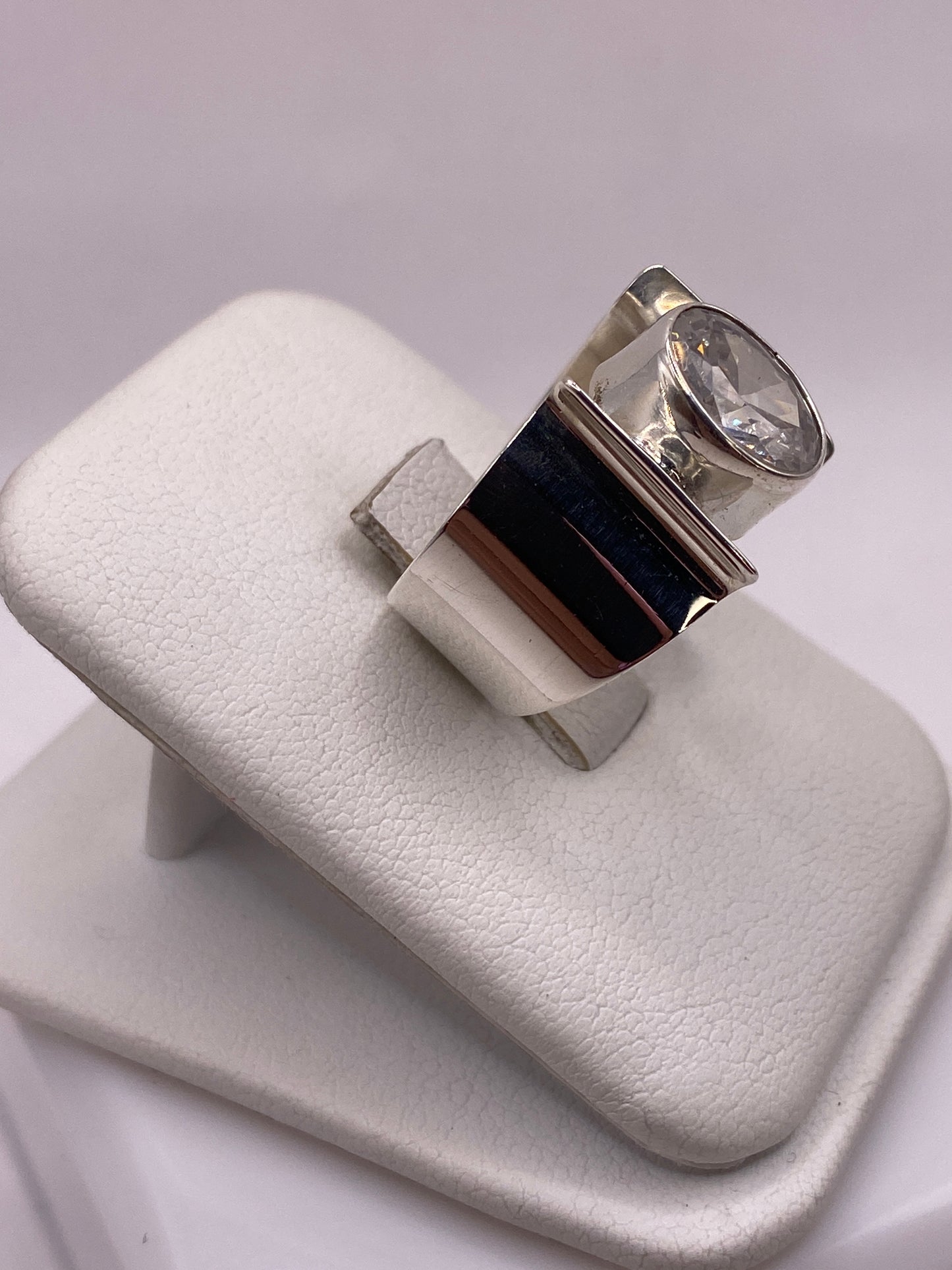 Detalle lateral del anillo mostrando el engaste de la circonia blanca en plata pulida