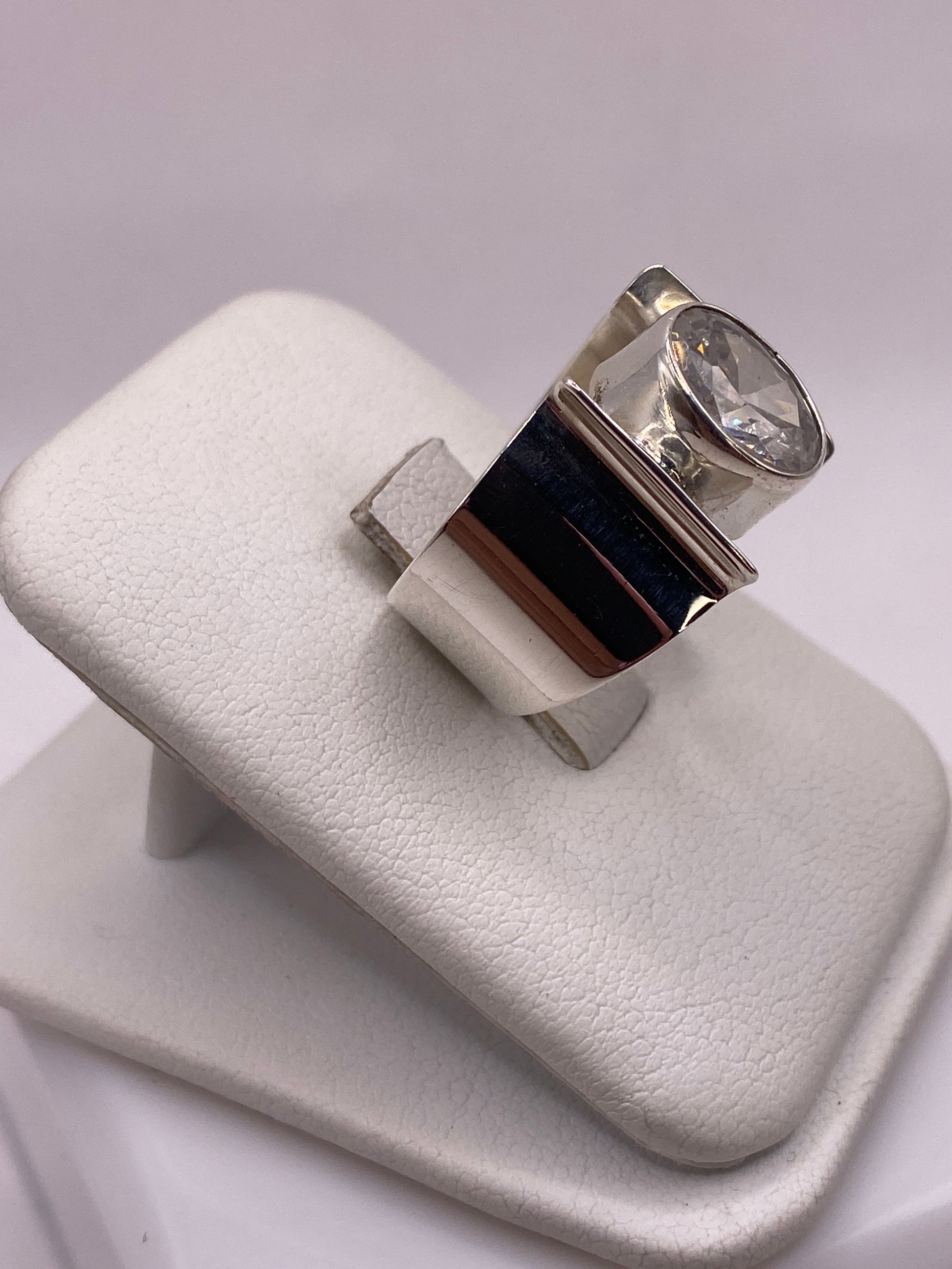 Detalle lateral del anillo mostrando el engaste de la circonia blanca en plata pulida