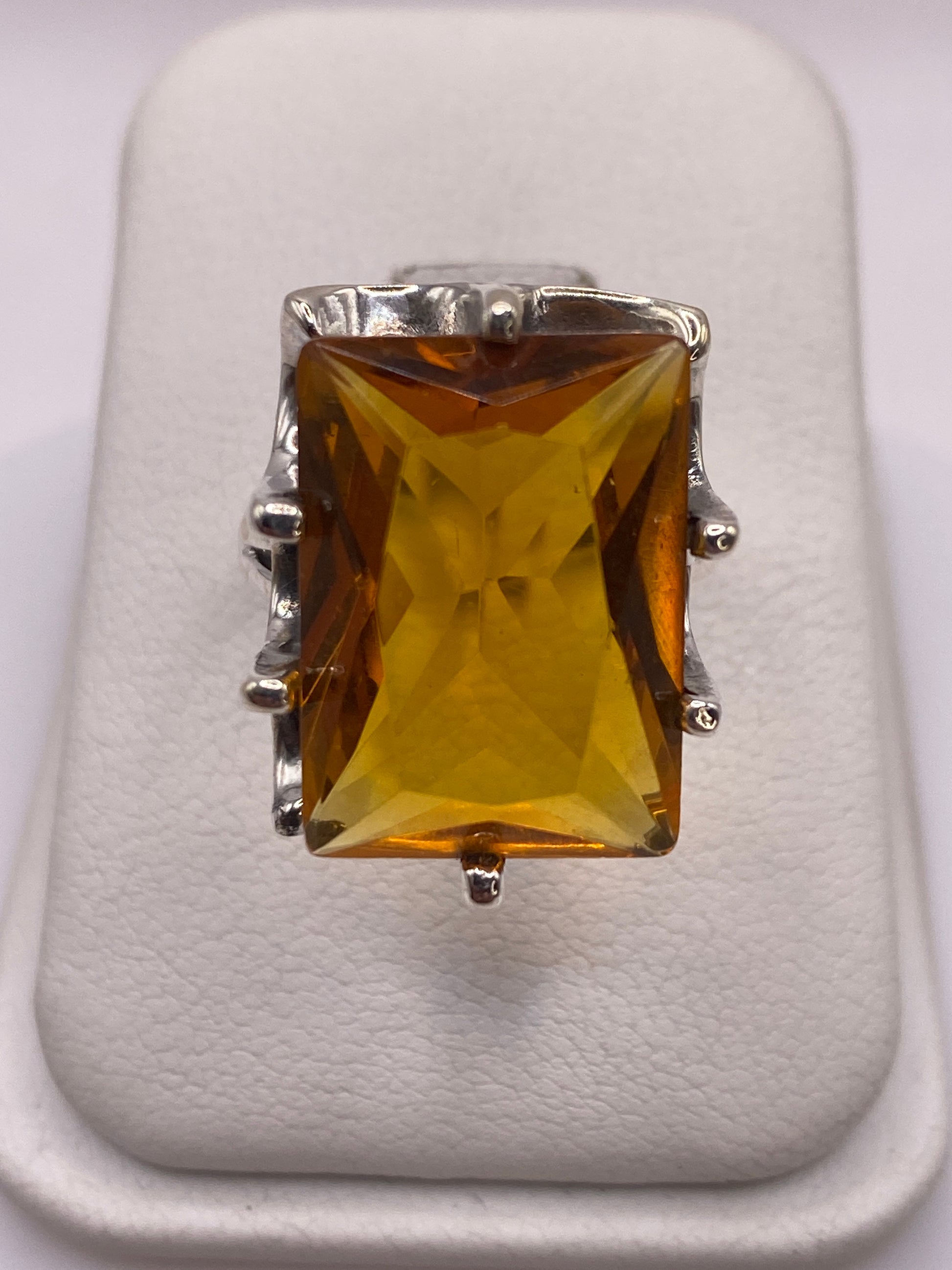 Anillo de plata solitario con circonia amarilla dorada sobre fondo blanco, vista frontal
