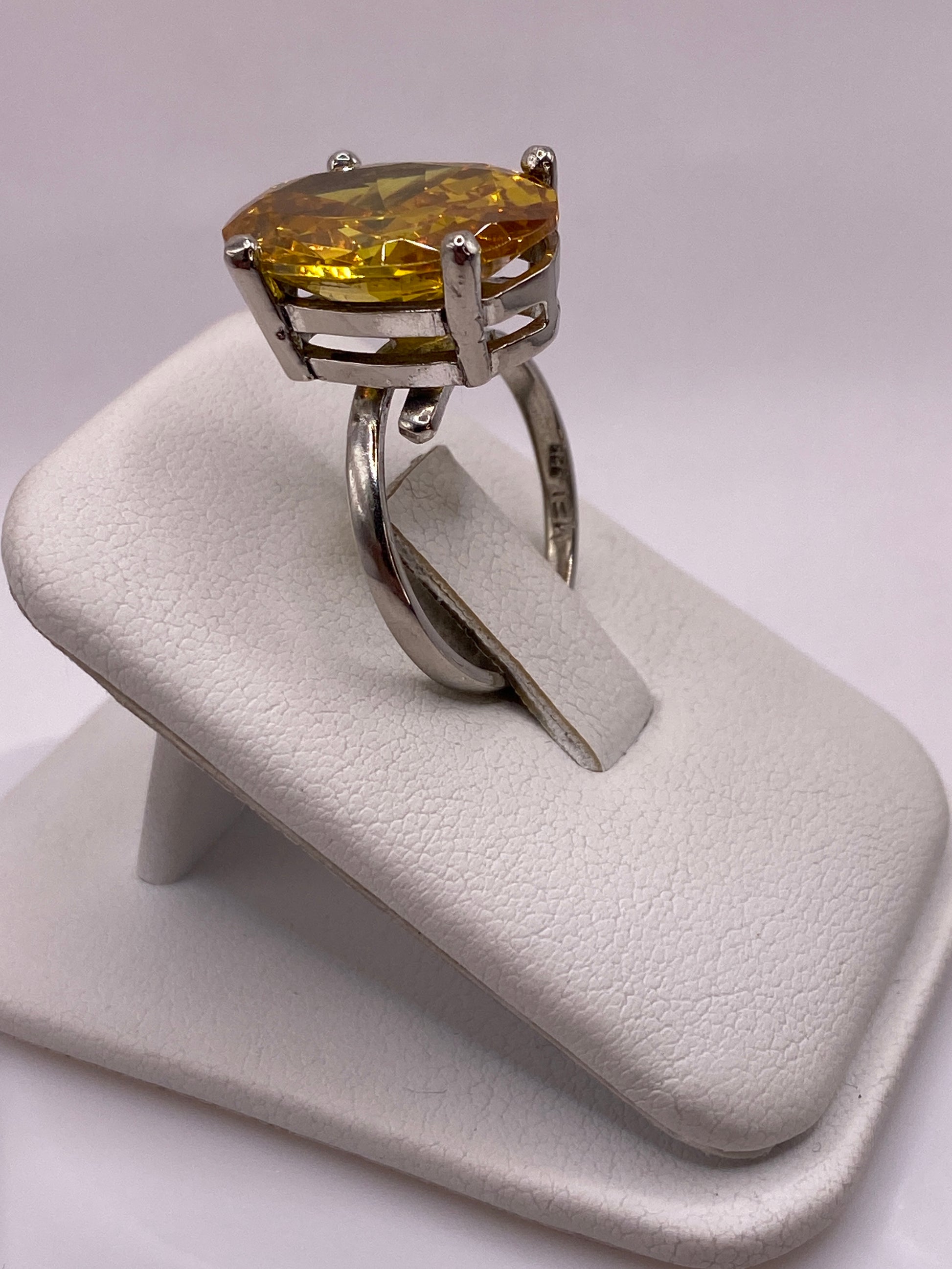 Anillo ajustable con circonia amarilla dorada en la mano de una mujer