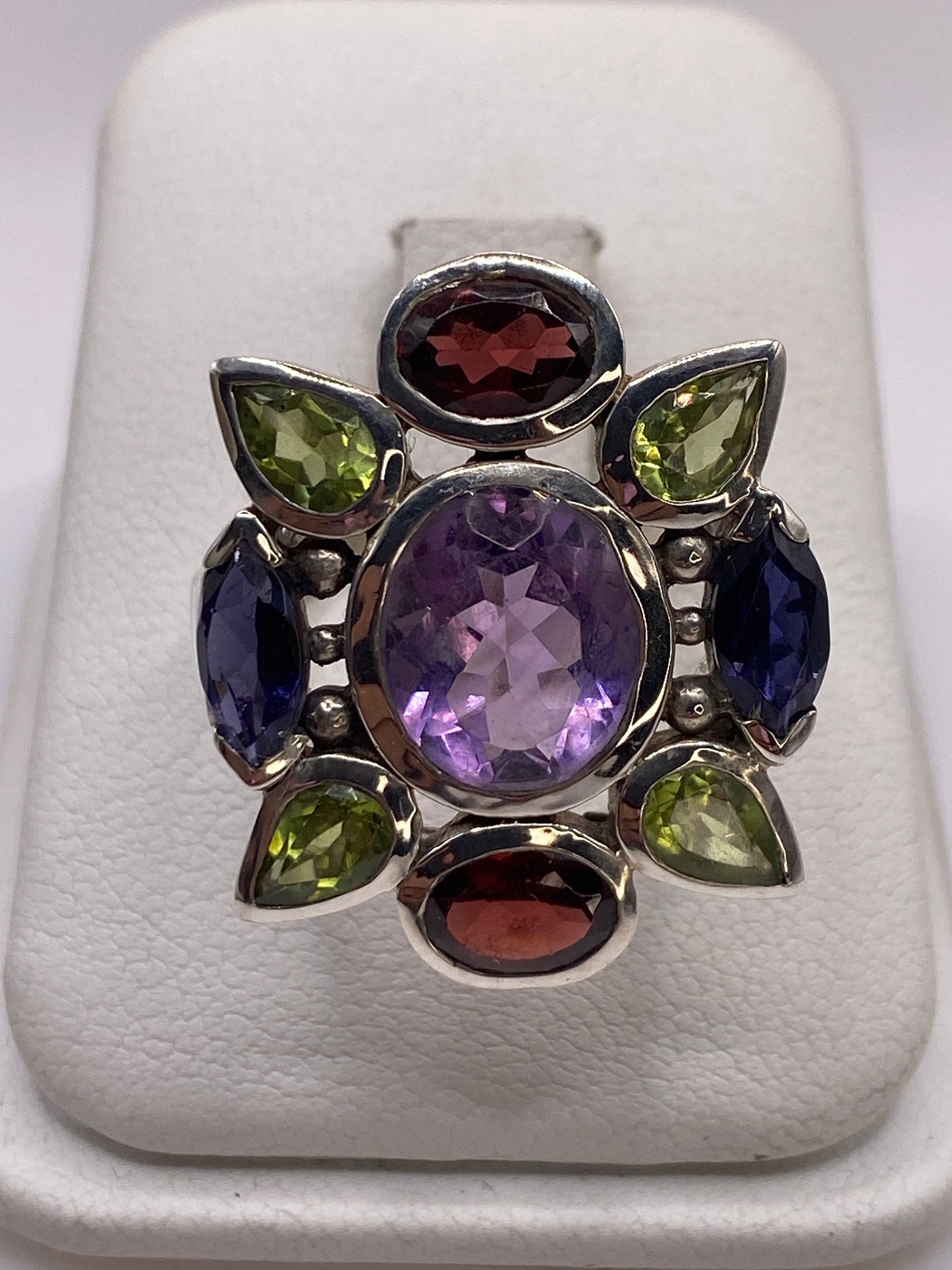 Anillo de plata coctel con ocho circonias multicolor púrpura azul verde y rojo, vista superior en estuche blanco