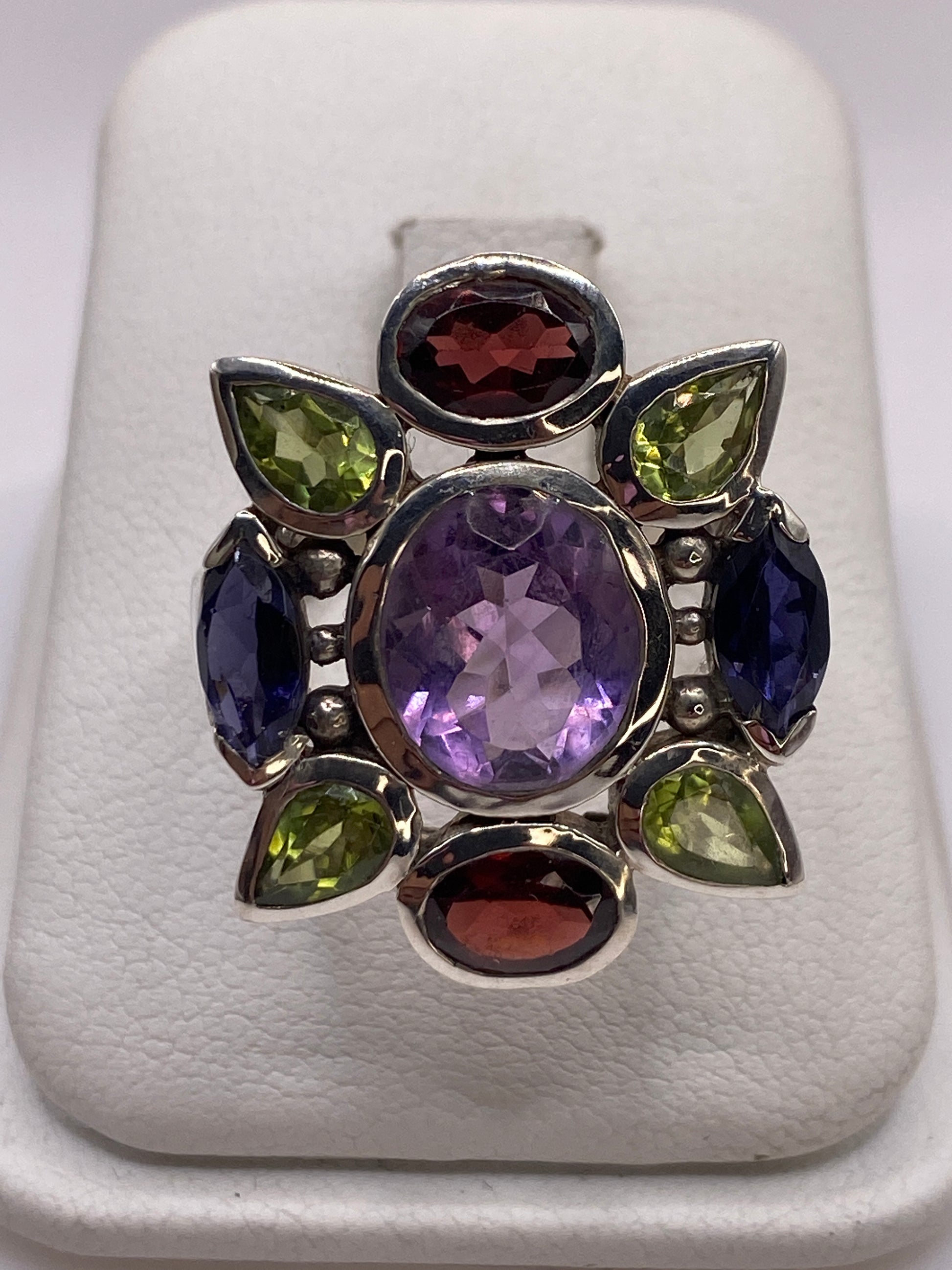 Anillo de plata coctel con ocho circonias multicolor púrpura azul verde y rojo, vista superior en estuche blanco