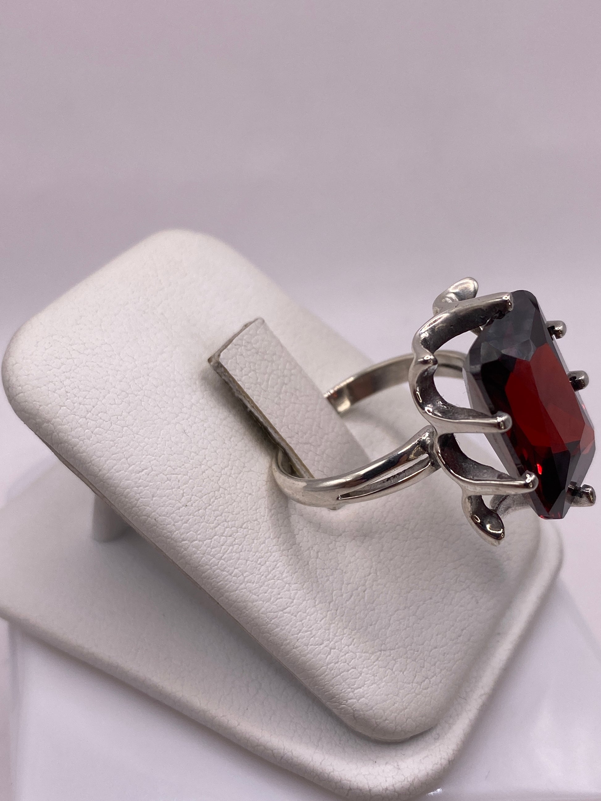 Vista lateral del anillo coctel de plata .925 con piedra roja rectangular