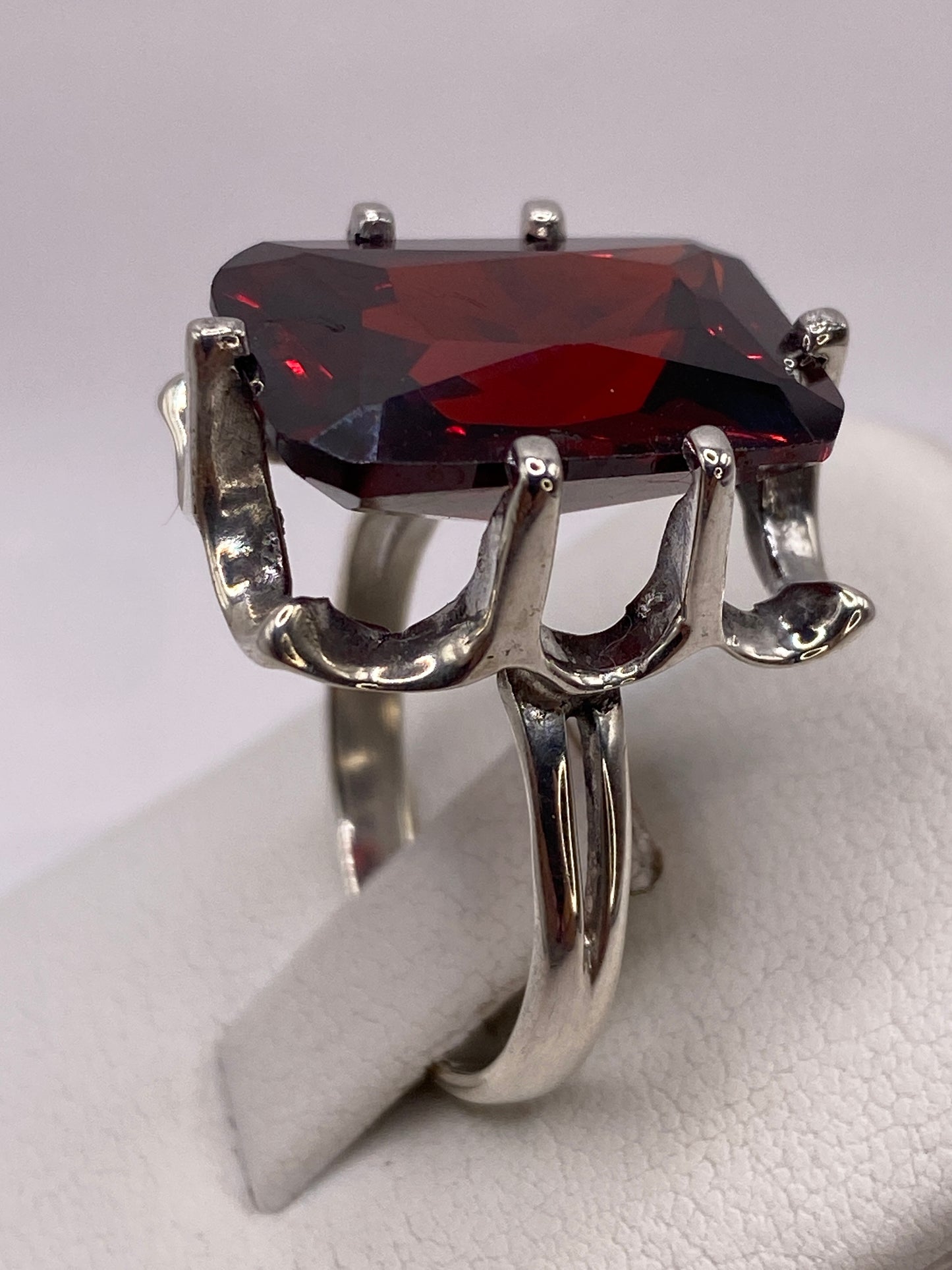 Detalle del engaste ornamental en plata de circonia roja facetada