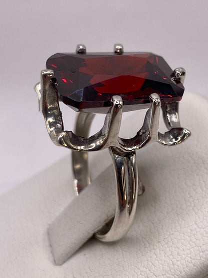 Detalle del engaste ornamental en plata de circonia roja facetada