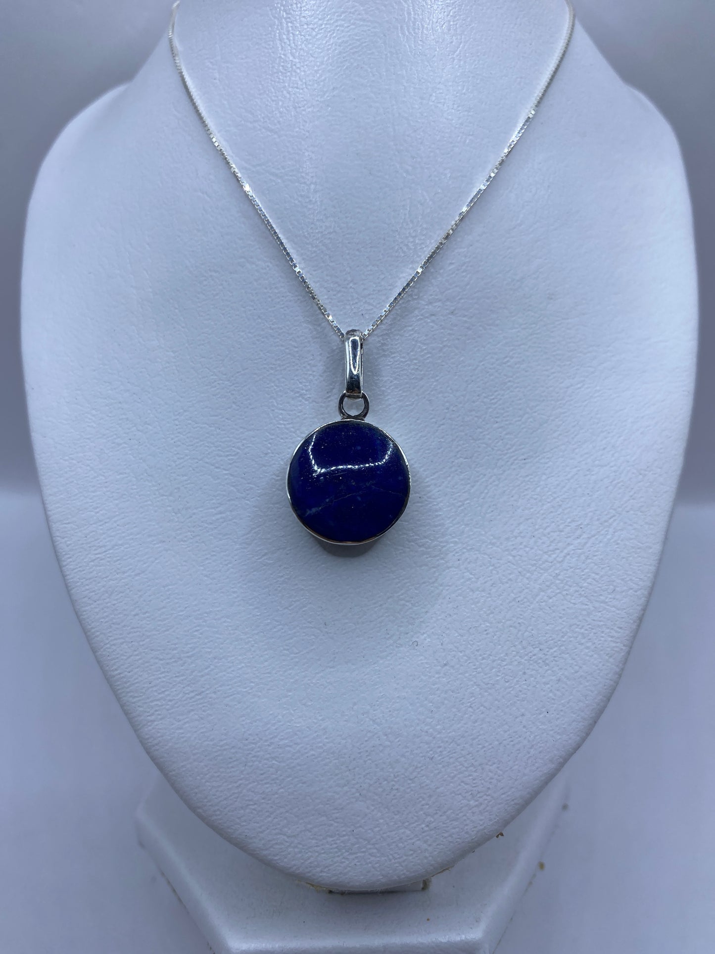 Detalle de la malaquita verde natural con vetas y el engaste de plata a mano