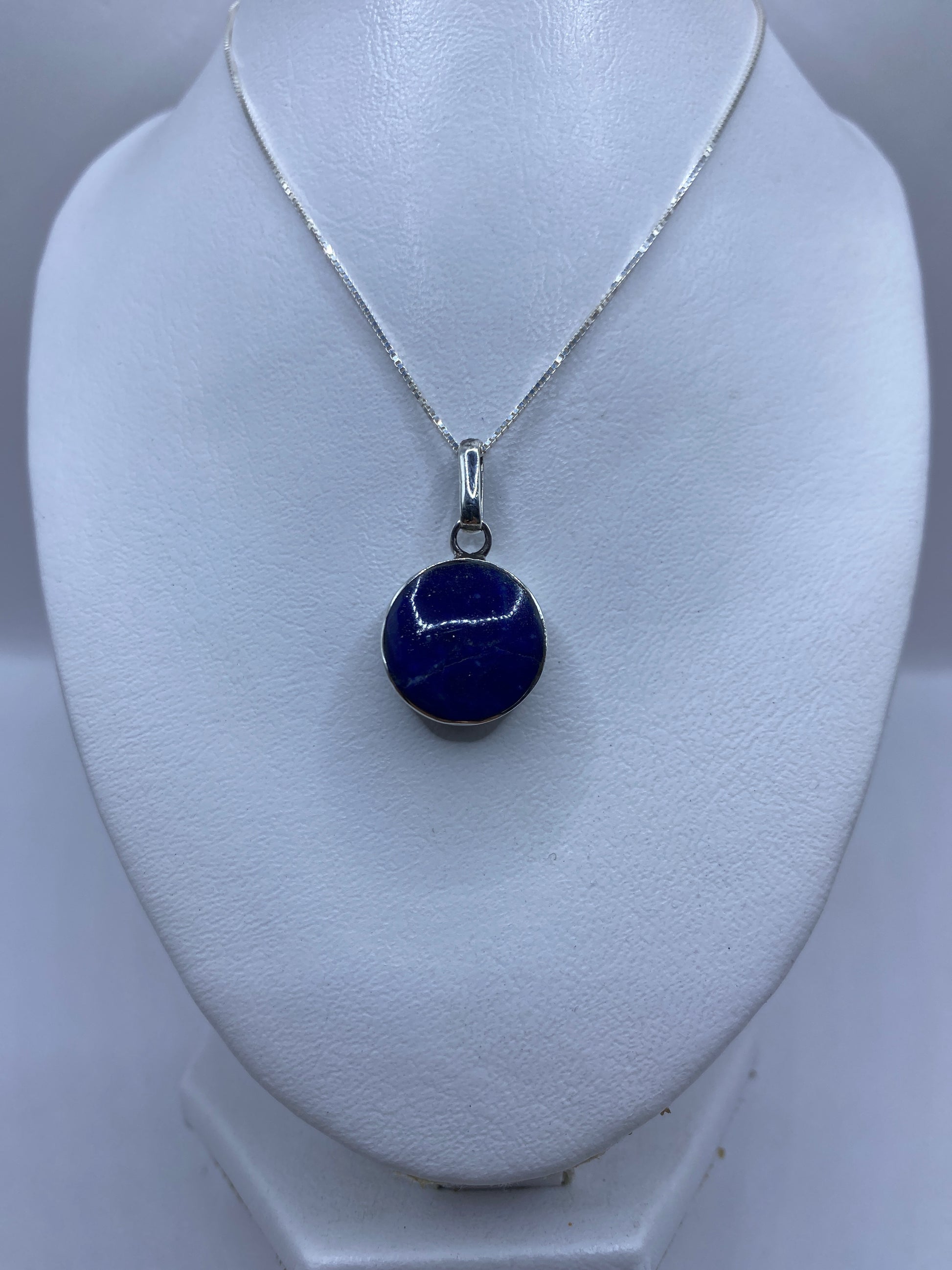 Detalle de la malaquita verde natural con vetas y el engaste de plata a mano