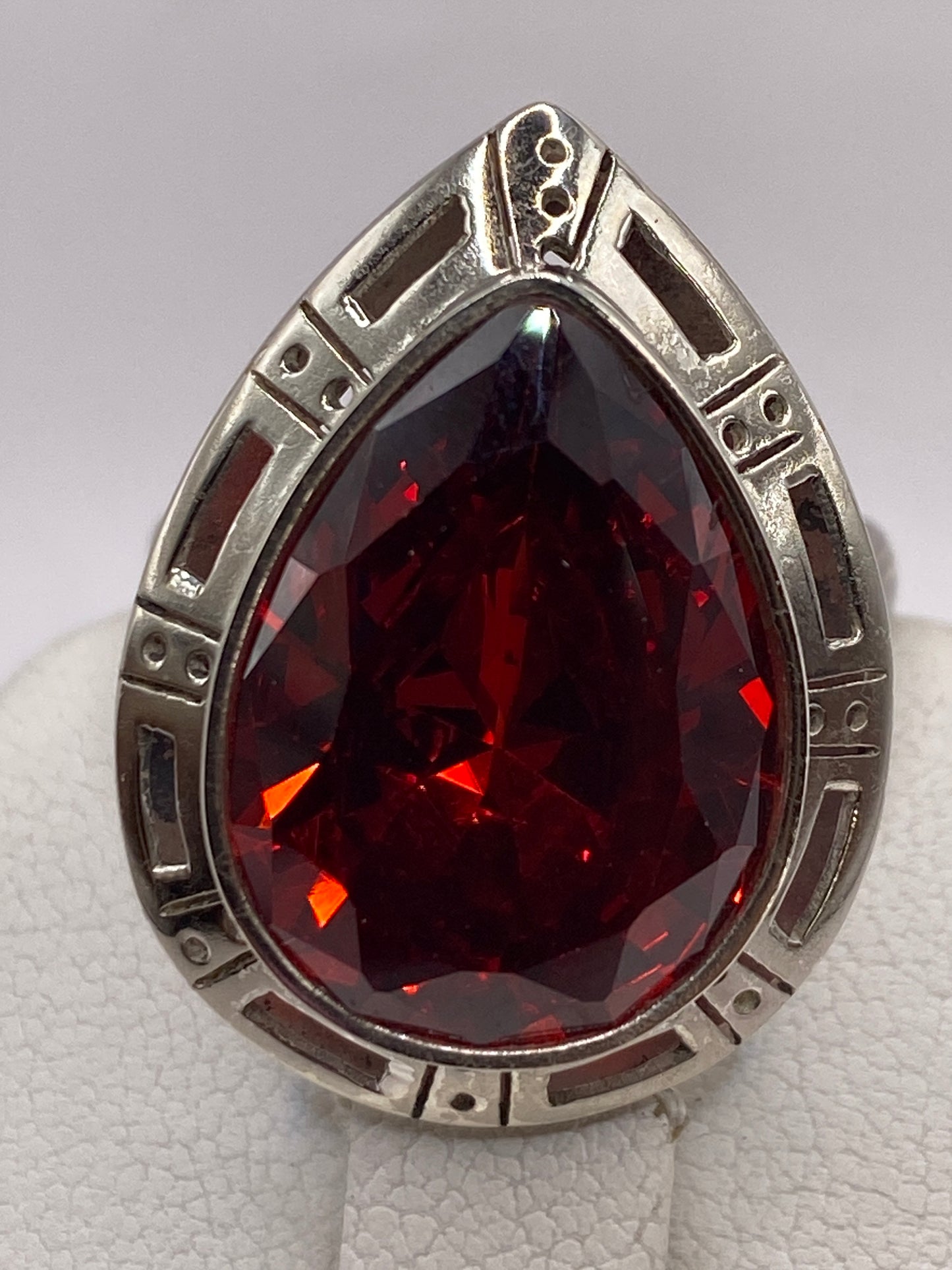 Anillo ajustable de plata con piedra roja, detalle del engaste geométrico