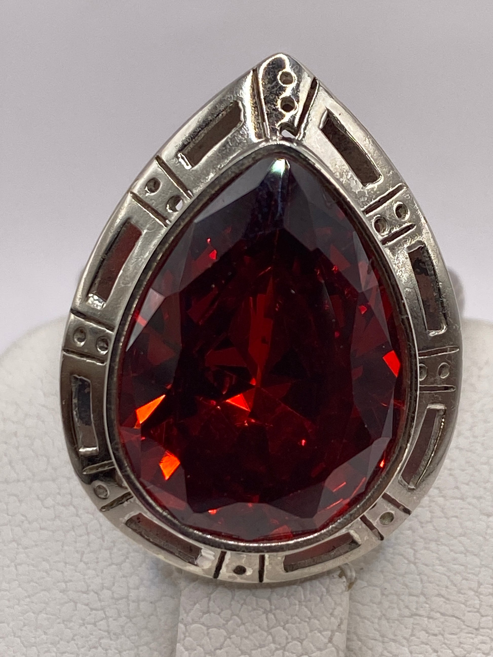 Anillo ajustable de plata con piedra roja, detalle del engaste geométrico