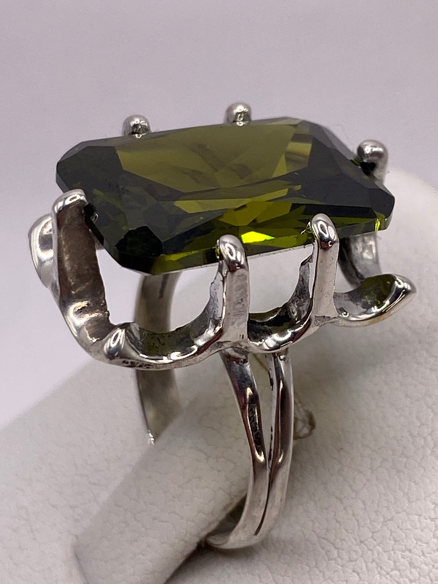Detalle de la circonia verde olivo capturando luz con brillo tipo diamante
