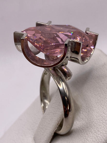 Anillo en dedo de mujer con uñas rosa, mostrando el brillo y dimensión de la piedra