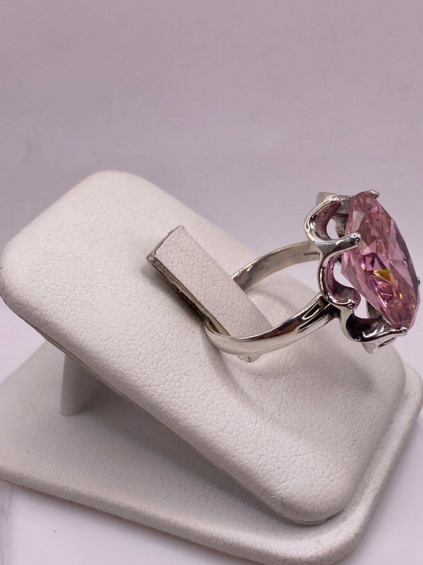 Vista lateral del anillo solitario circonia rosa en plata .925, banda calada detallada