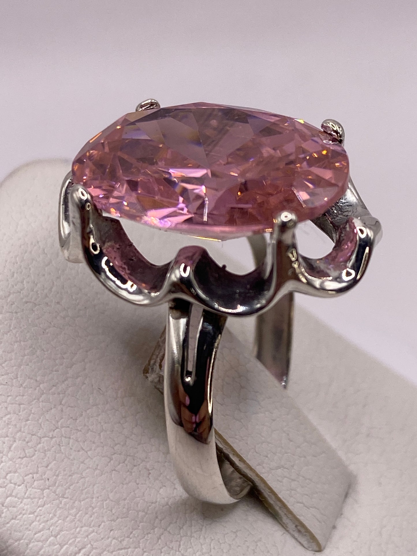 Anillo de plata circonia rosa en la mano, luciendo el brillo y fuego de la piedra