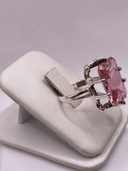 Vista lateral del anillo solitario rosa mostrando el engaste de cuatro patas en plata