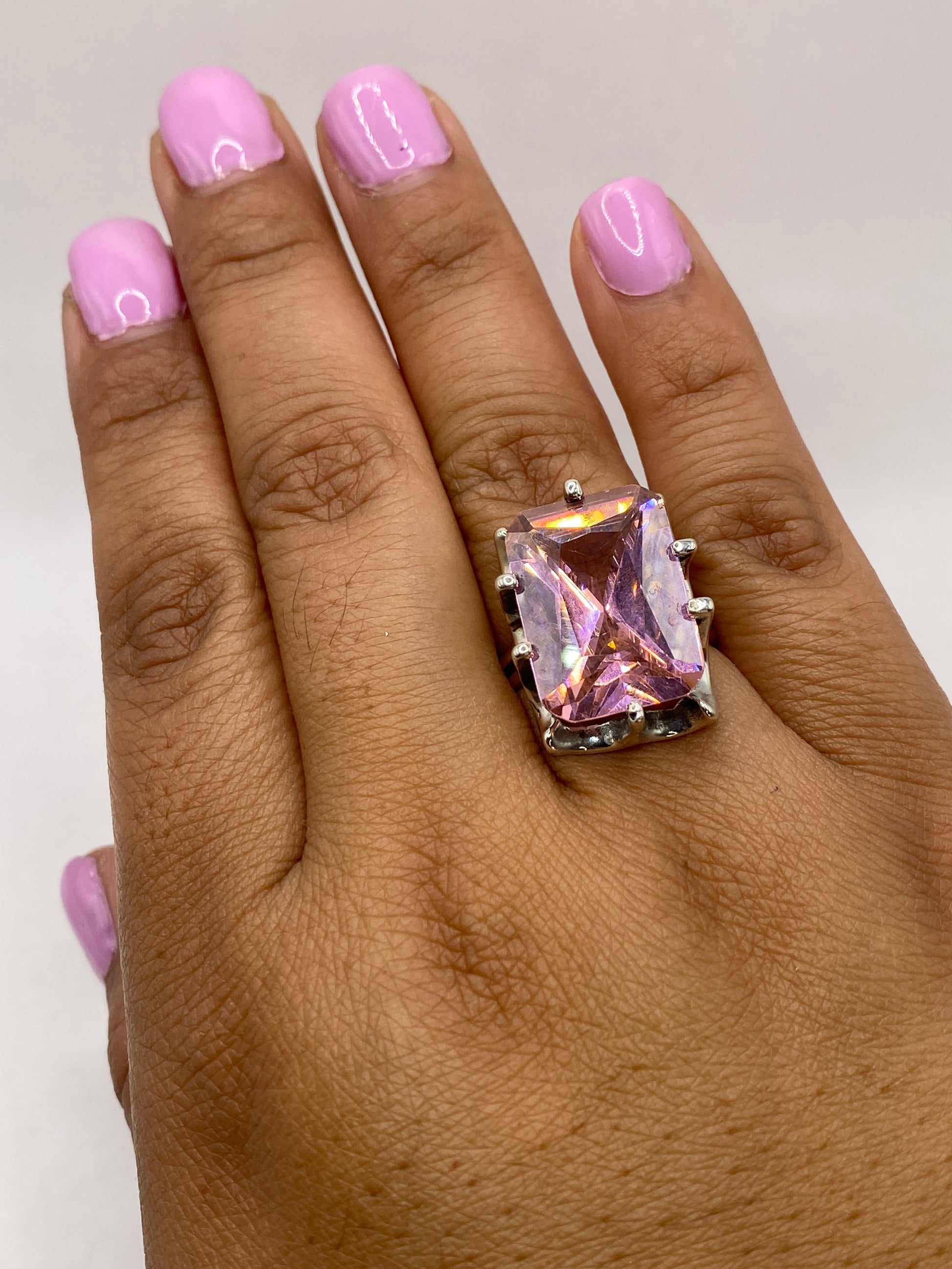 Anillo en dedo mostrando el tamaño y presencia real de la piedra rosa