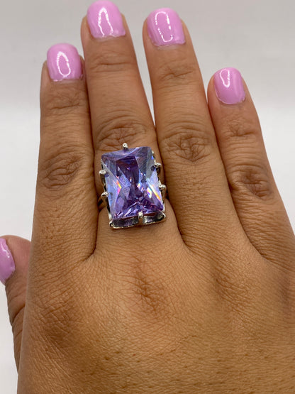 Anillo solitario morado en dedo de mujer mostrando el fuego y brillo de la piedra