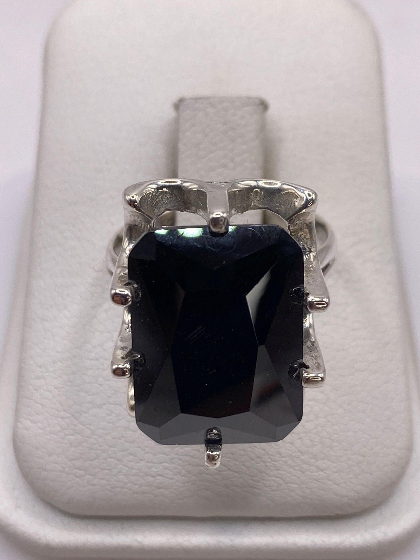 Anillo de plata solitario con circonia negra facetada sobre fondo blanco