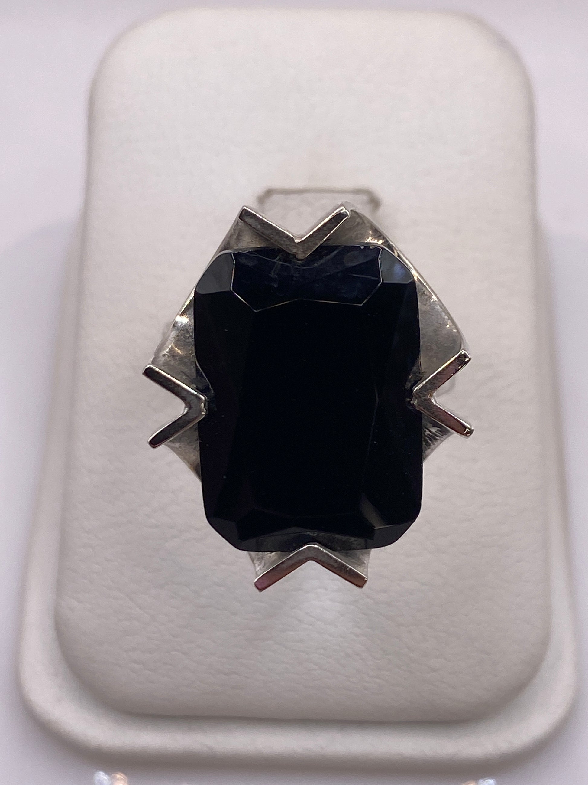 Anillo de plata solitario con circonia negra facetada, vista frontal sobre fondo blanco