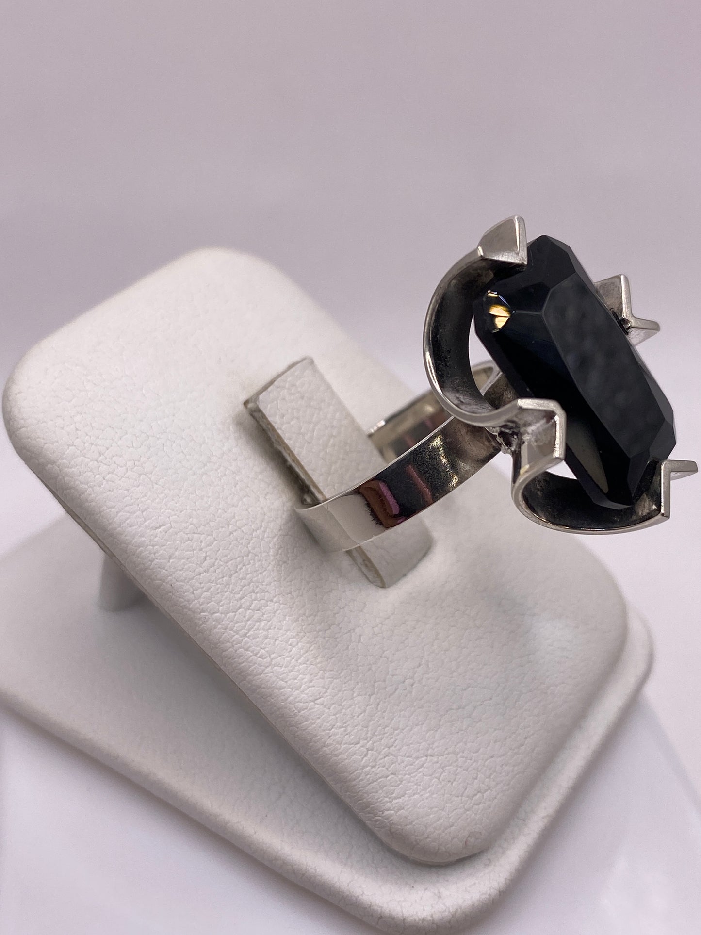 Anillo de circonia negra en la mano mostrando el brillo intenso y profundidad de la piedra