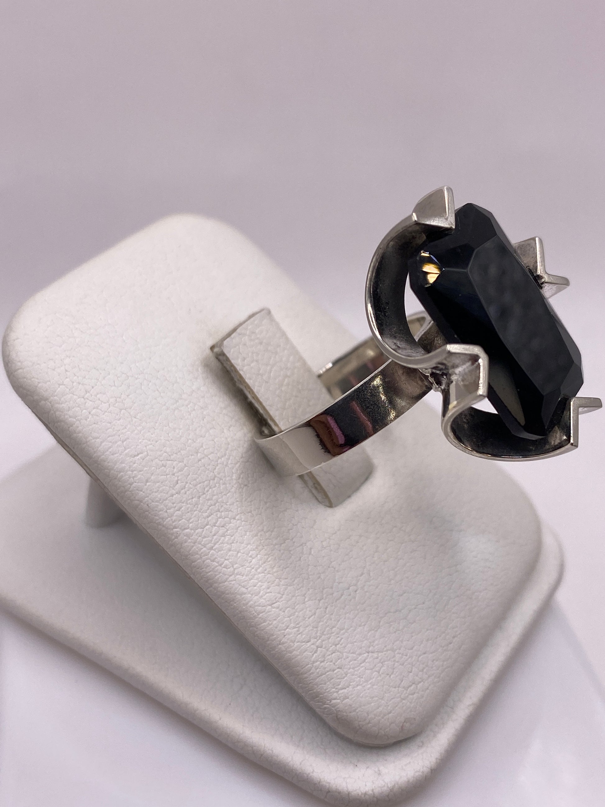 Anillo de circonia negra en la mano mostrando el brillo intenso y profundidad de la piedra