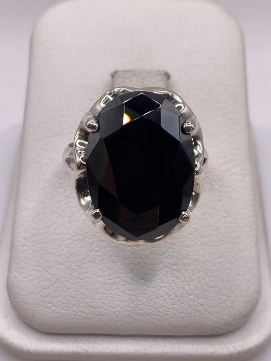 Anillo solitario de plata con circonia negra facetada frente a la cámara