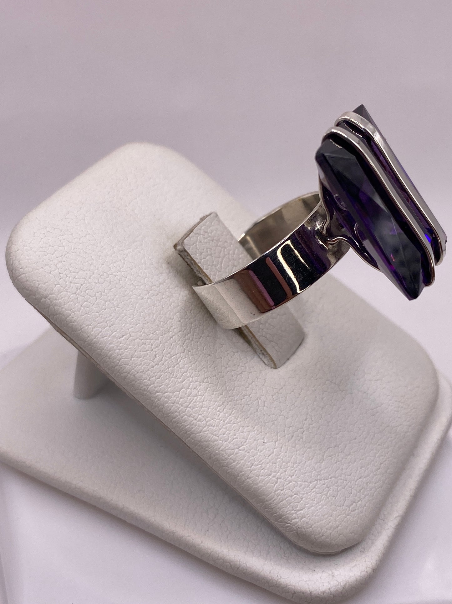 Detalle lateral del anillo mostrando bandas de plata pulida y solitario