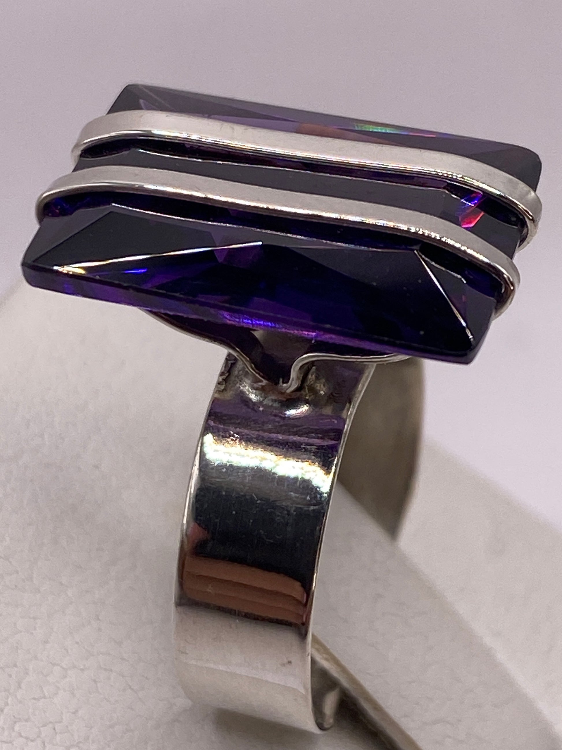 Anillo en mano femenina con uñas de color rosa, lado opuesto