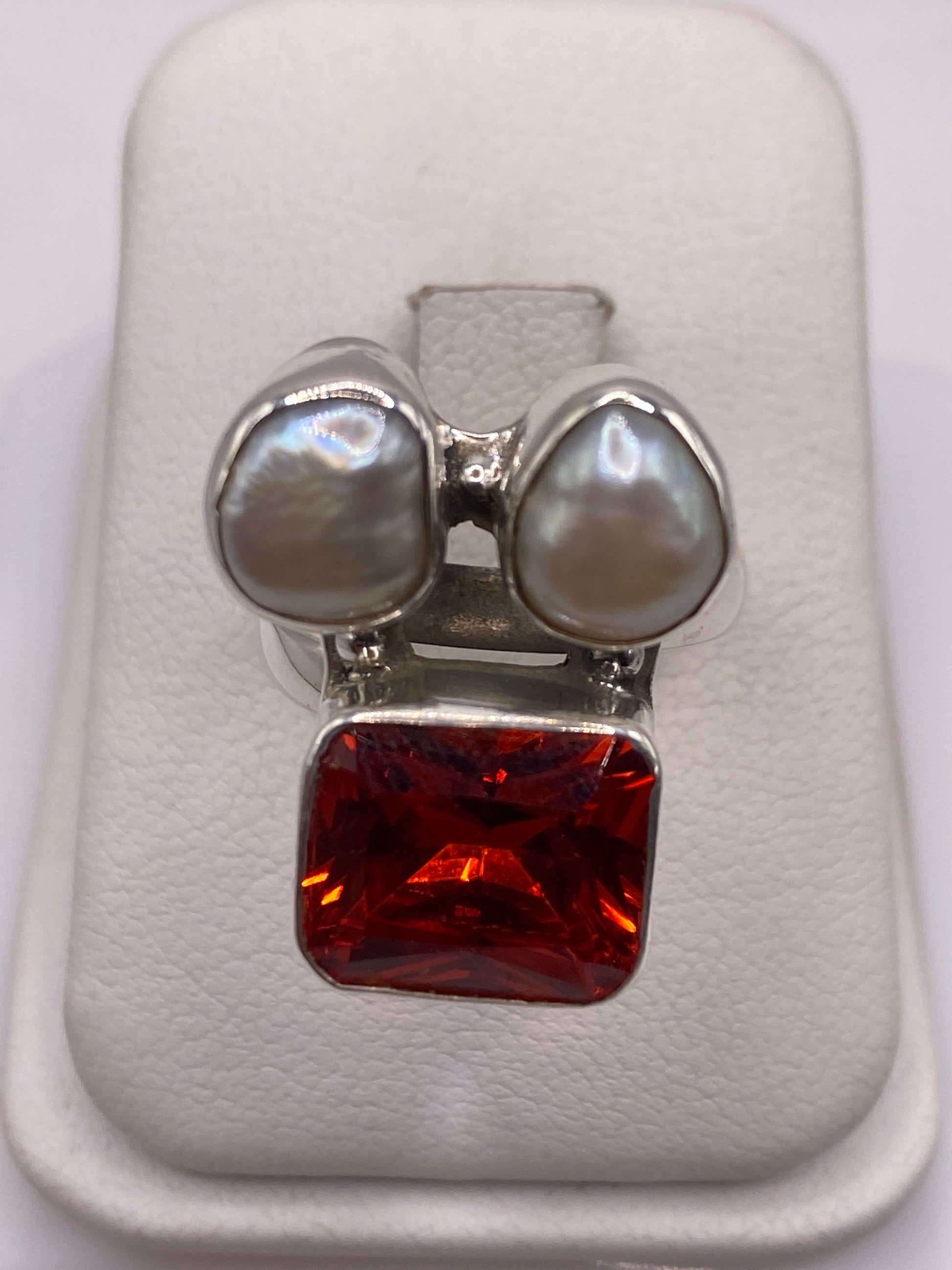 Anillo ajustable de plata con circonia naranja fuego y dos perlas blancas en caja de presentación
