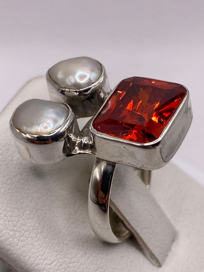 Detalle de la circonia naranja rectangular en engaste de plata con perlas