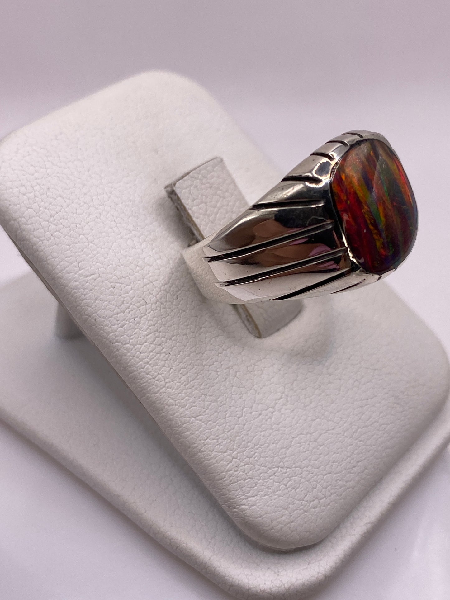 Vista lateral del anillo con banda ancha y franjas decorativas en plata pulida