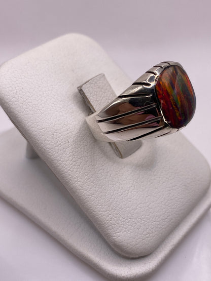 Vista lateral del anillo con banda ancha y franjas decorativas en plata pulida