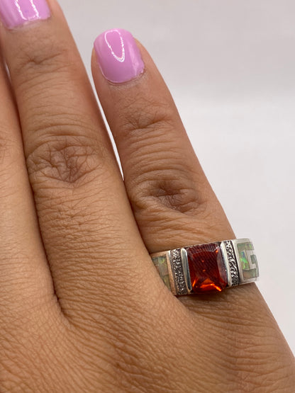 Anillo ópalo de fuego puesto en dedo mostrando el brillo y movimiento de color