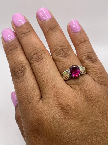 Anillo sobre fondo blanco con ópalo de fuego reflejando luz multicolor