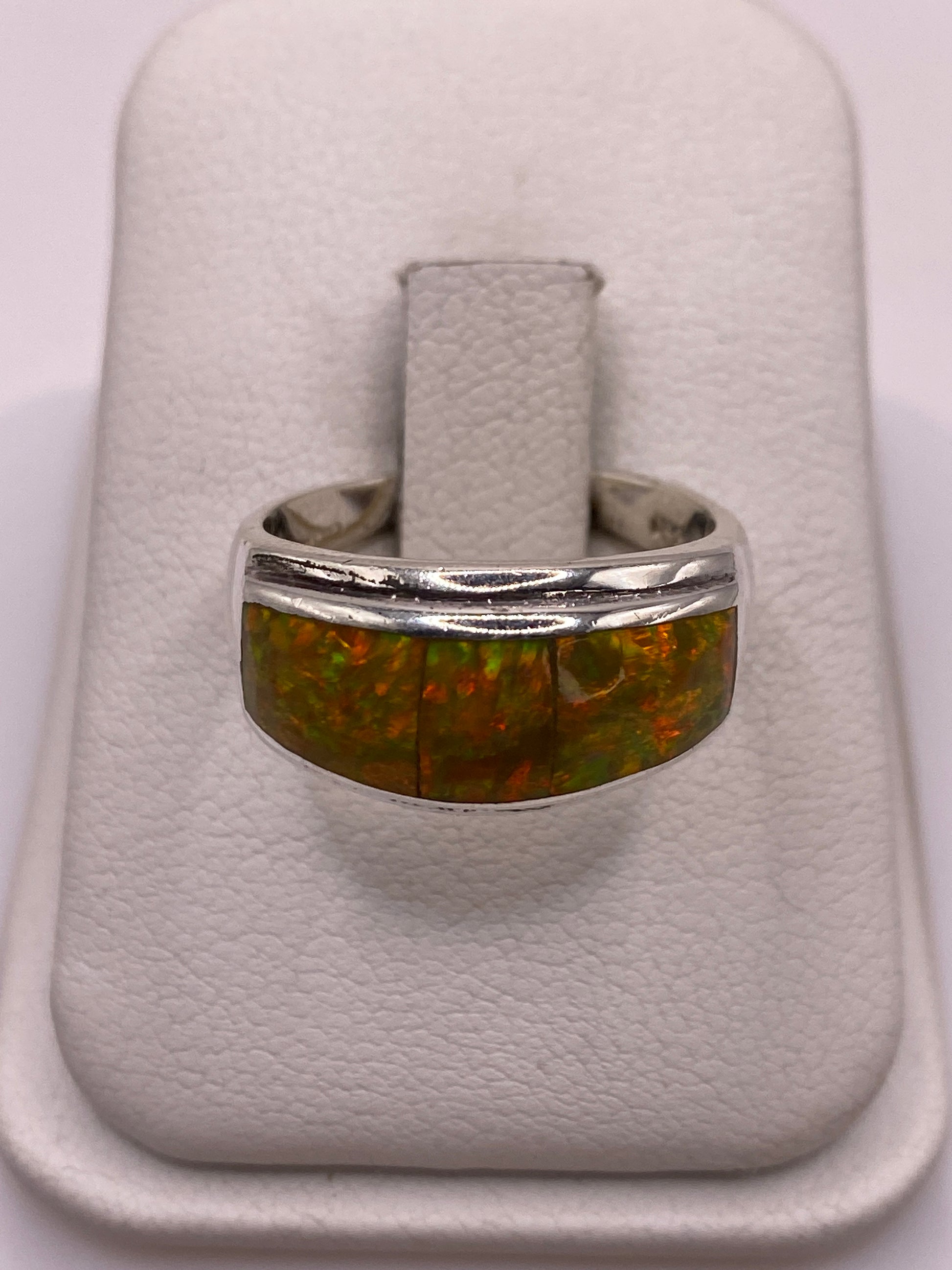 Anillo de plata con ópalo de fuego amarillo y naranja en mano de mujer