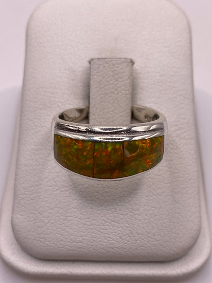 Anillo de plata con ópalo de fuego amarillo y naranja en mano de mujer