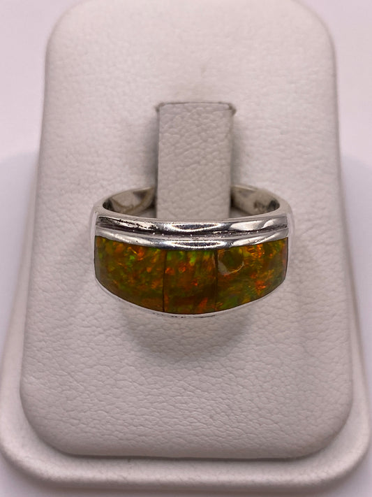 Anillo de plata con ópalo de fuego amarillo y naranja en mano de mujer