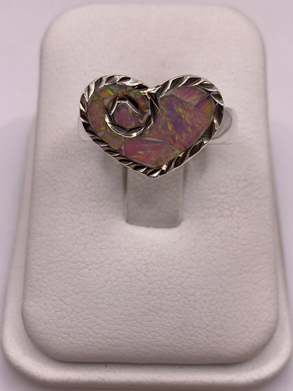 Anillo de plata con ópalo de fuego multicolor, vista frontal mostrando el juego de colores púrpura, verde y dorado