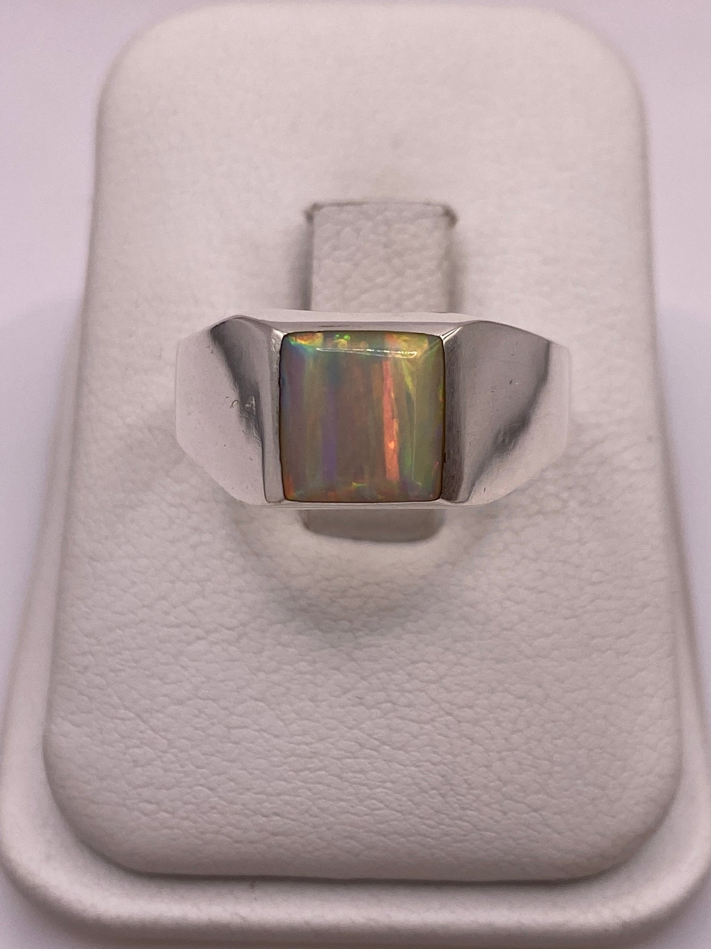 Anillo de plata solitario con ópalo de fuego multicolor mostrando fuego amarillo, verde y rojo
