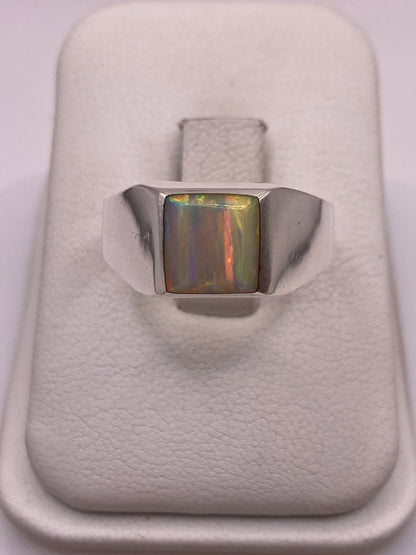 Anillo de plata solitario con ópalo de fuego multicolor mostrando fuego amarillo, verde y rojo