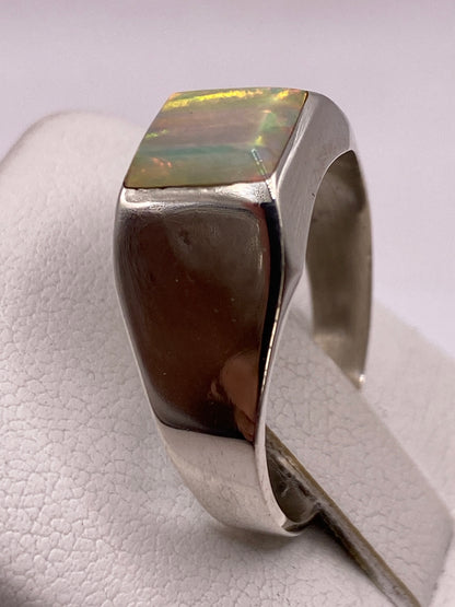 Detalle lateral del anillo mostrando la piedra ópalo de fuego con su juego de colores único