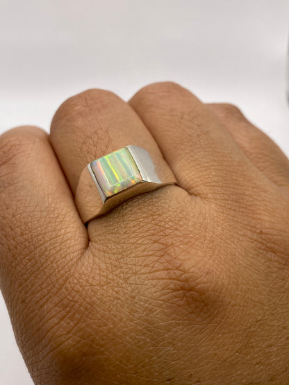 Anillo en mano mostrando la presencia y el tamaño del ópalo de fuego natural en plata de Taxco