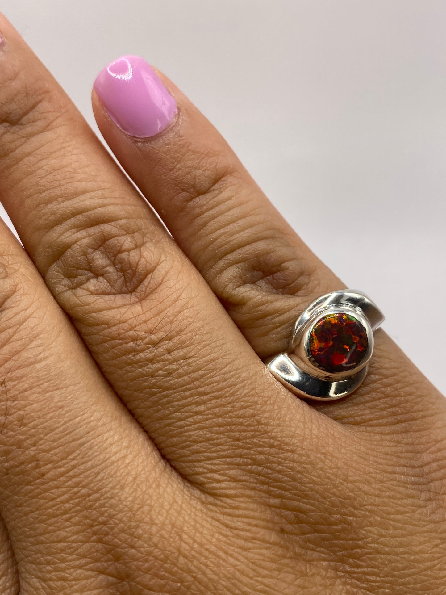 Anillo en dedo mostrando la vivacidad de fuego del ópalo y el sello .950 MEXICO en la banda
