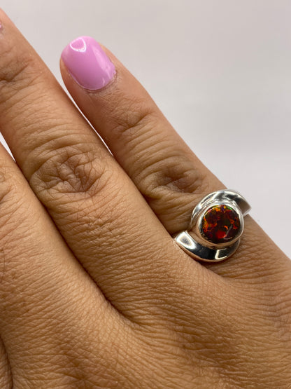 Anillo en dedo mostrando la vivacidad de fuego del ópalo y el sello .950 MEXICO en la banda