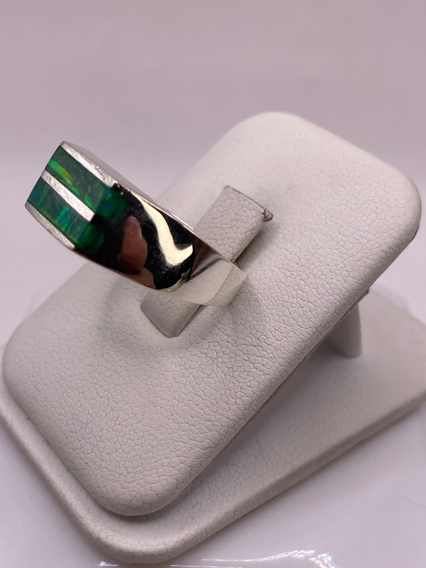 Detalle lateral del anillo mostrando el engaste robusto del ópalo de fuego en plata .925